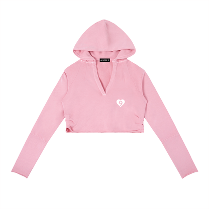 Pink cropped hoodie with a small logo on a white background